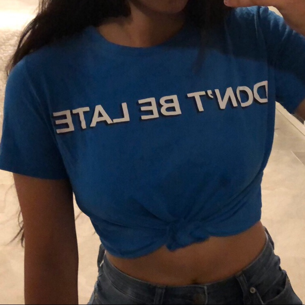 A blue t-shirt saying “don’t be late”